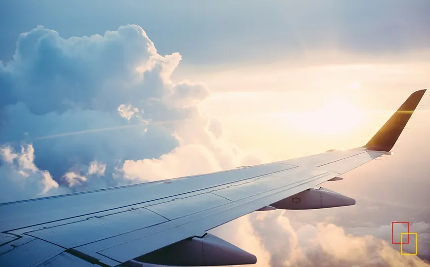 Ala de un avión en pleno vuelo al atardecer entre las nubes
