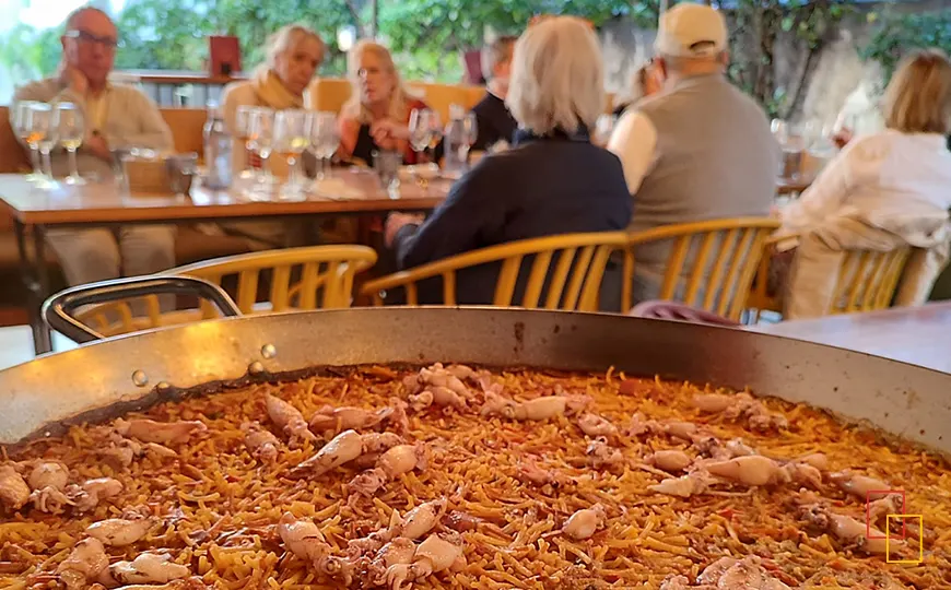 Paellera de arroz de marisco durante una comida en terraza en Sanlúcar de Barrameda