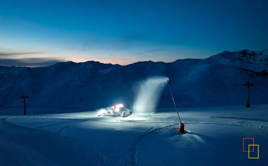 Producción de nieve en la estación de Baqueira Beret al atardecer