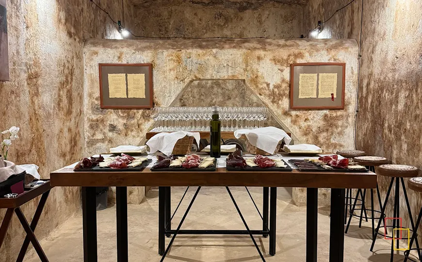 Mesa preparada con copas y detalles de luz tenue en las cavas subterráneas