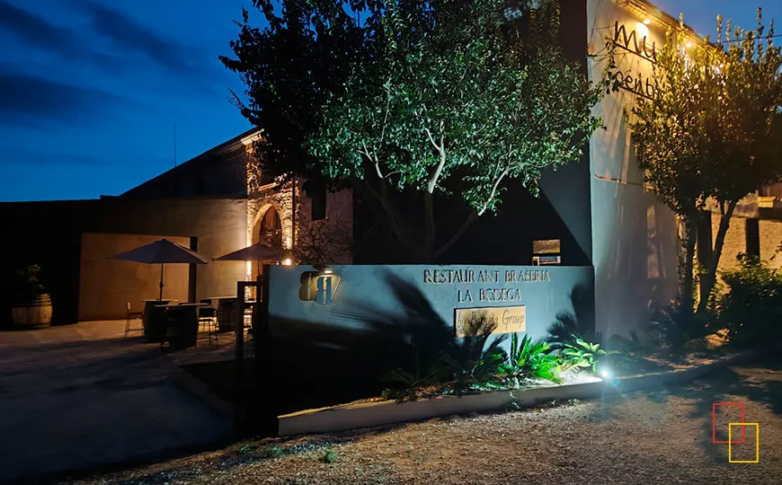 Entrada nocturna de Bodegues Besalduch Valls & Bellmunt y del restaurante brasería La Bodega iluminados