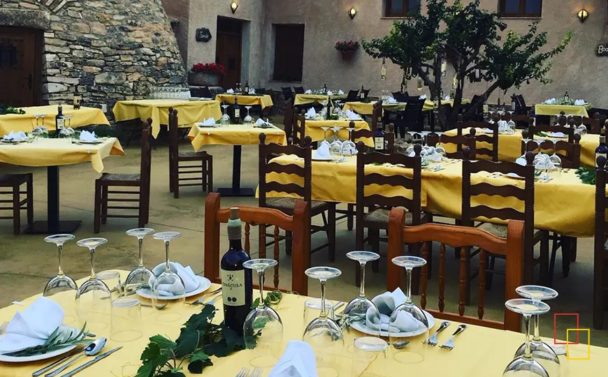 Patio del restaurante de Bodega Las Calzadas con mesas preparadas en verano