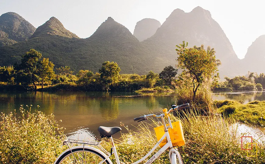 Bicicleta junto a río y montañas kársticas en Yangshuo