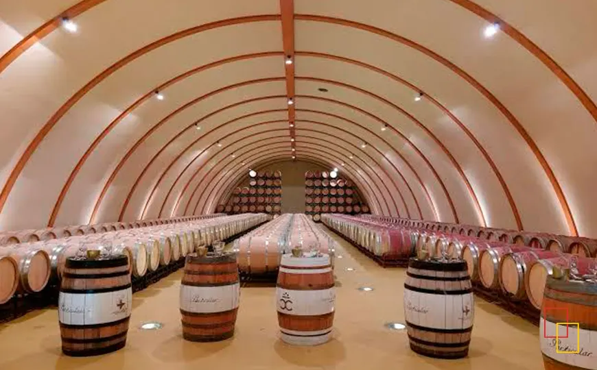 Mesa de cata preparada en la sala de barricas de Tierra de Cubas con copas y botellas