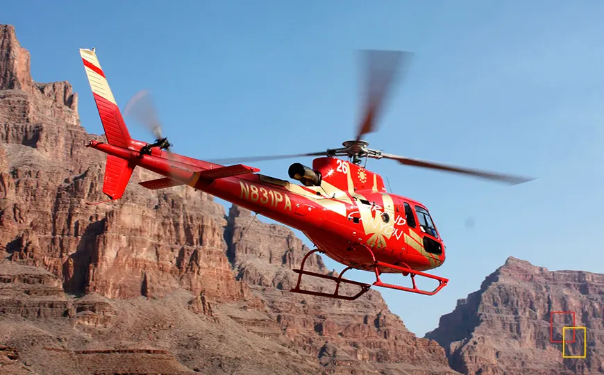 Helicóptero rojo sobrevolando los acantilados del Grand Canyon West