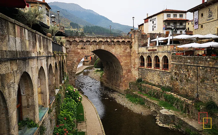 Casco histórico de Potes con puente medieval y montañas de fondo