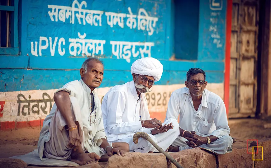 Vecinos de Jodhpur sentados junto a un muro con carteles en hindi