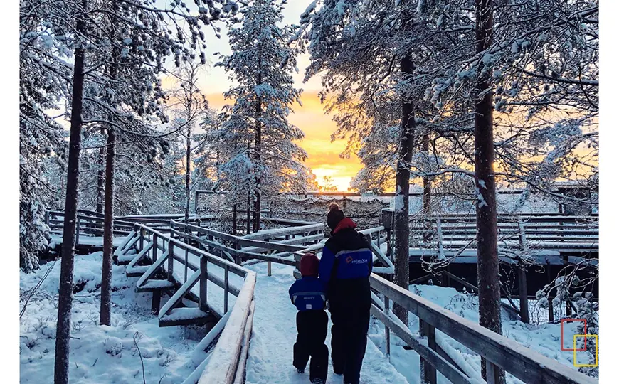Familia caminando por la nieve en Laponia