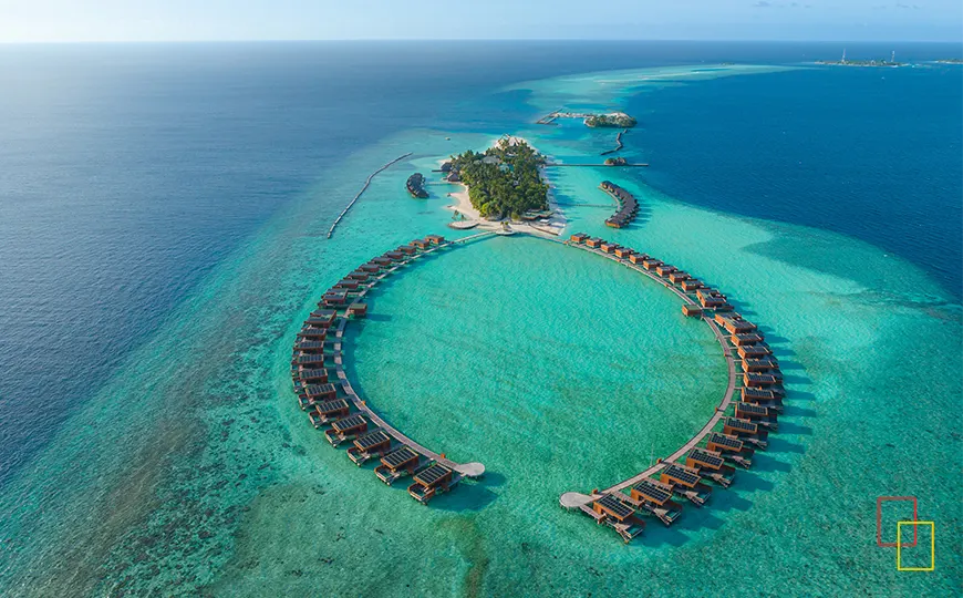 Vista aérea de isla-resort con dos arcos de villas sobre el agua