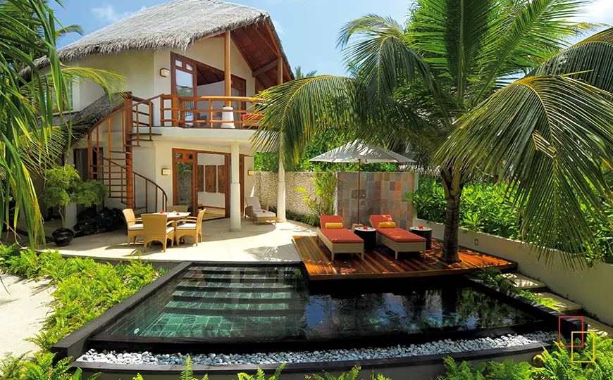 Villa de playa de dos plantas con vegetación tropical y acceso directo a la arena