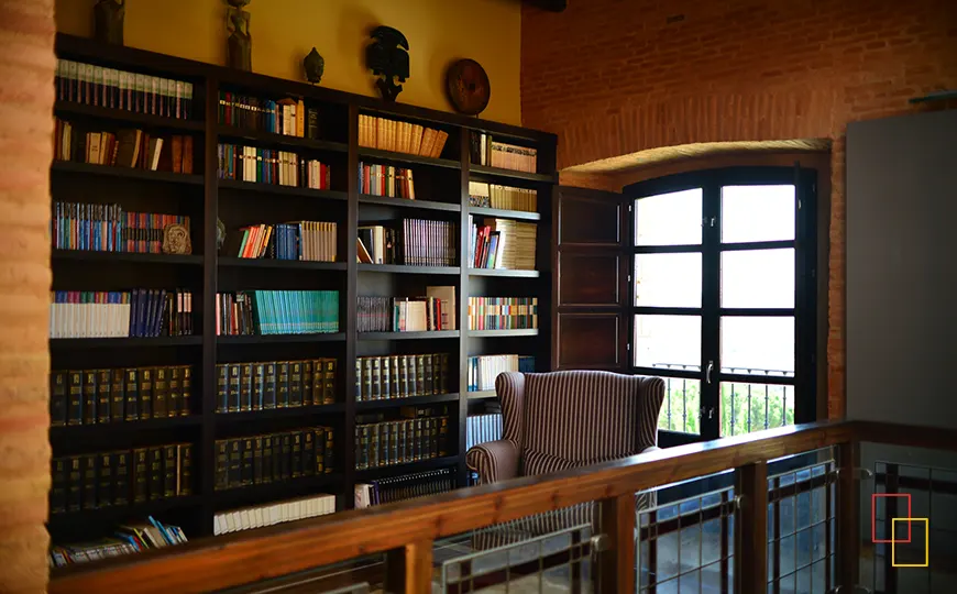 Biblioteca con ladrillo visto y madera en el castillo de Monte la Reina