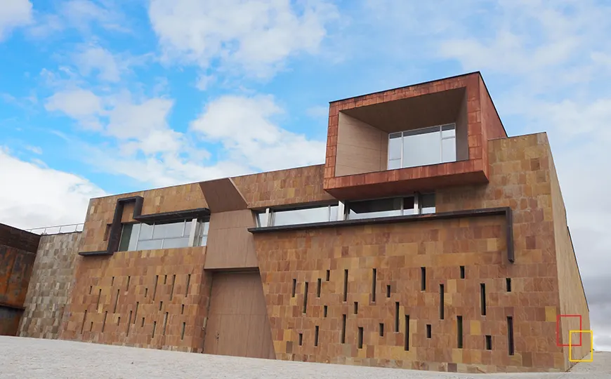 Fachada contemporánea de la bodega de Monte la Reina con cielo despejado al atardecer