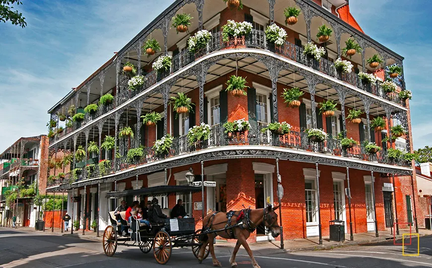 Balcón de hierro forjado y carruaje en el Barrio Francés de Nueva Orleans