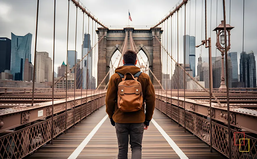 Viajero caminando por la pasarela del Puente de Brooklyn con el skyline de fondo