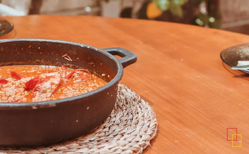 Plato de arroz marinero servido en mesa para maridar con manzanilla en una experiencia en Sanlúcar