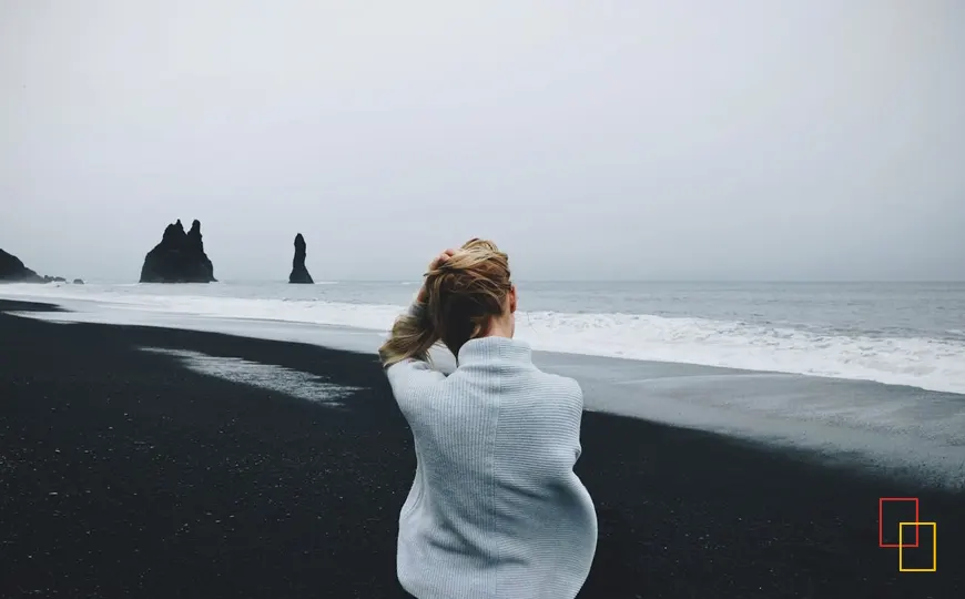 Playa de arena negra en Islandia con vistas al mar y formaciones rocosas