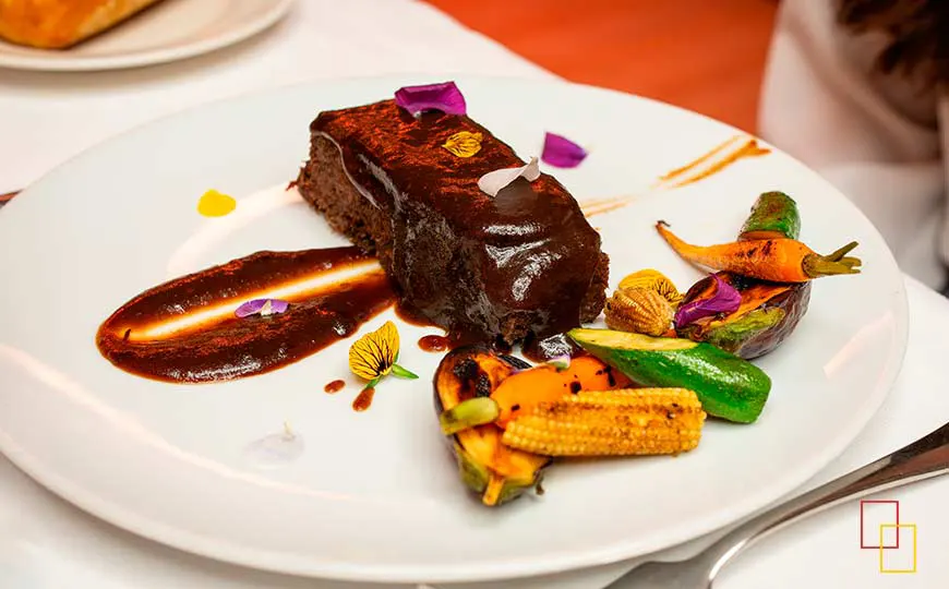 Rabo de toro confitado a baja temperatura con salsa de vermú y verduritas salteadas