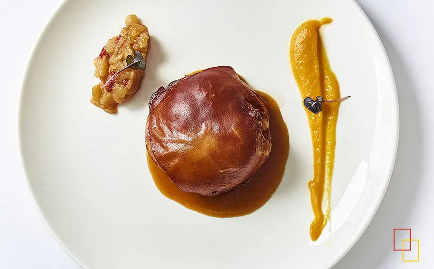 Cochinillo confitado y asado, crema de calabaza y chutney de frutas