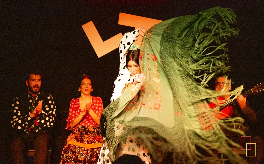 Bailaora en plena actuación en Tablao Flamenco Las Tablas (Madrid) con el cuadro flamenco al fondo