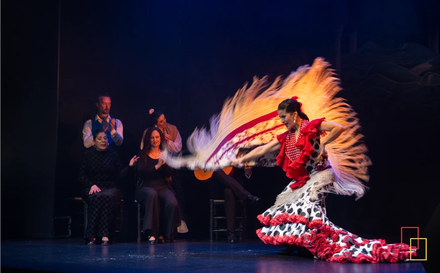 Bailaora con bata de cola y mantón en el escenario de Teatro Flamenco Madrid