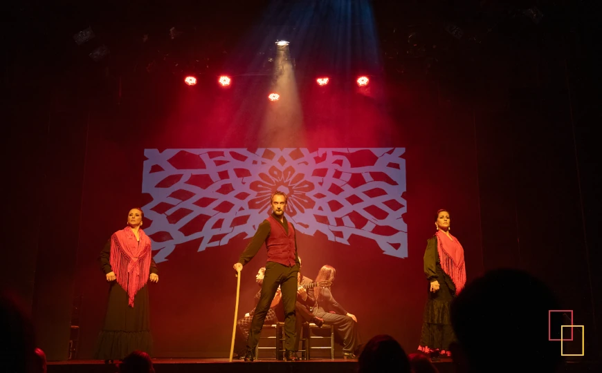 Escena flamenca con iluminación roja en Teatro Flamenco Madrid