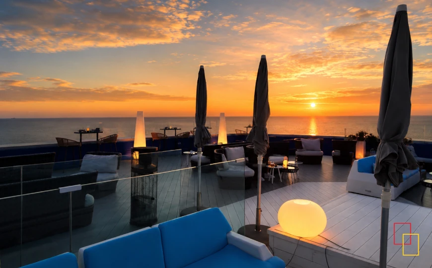 Terraza chill out con vistas al mar al atardecer en hotel de costa