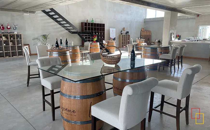 Sala de catas y wine-bar de Dominio Lubiano con mesas sobre barricas y botellas de vino